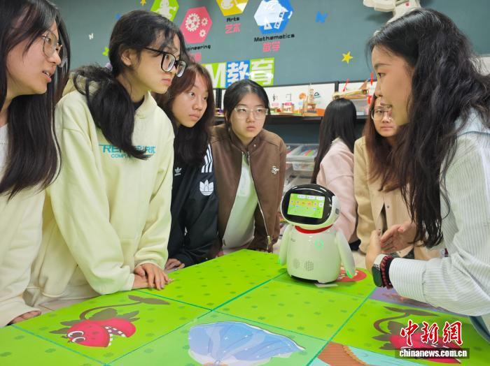 圖為“嬰幼兒發(fā)展與健康管理”專業(yè)學生與老師一起設計嬰幼兒互動游戲。黨田野 攝