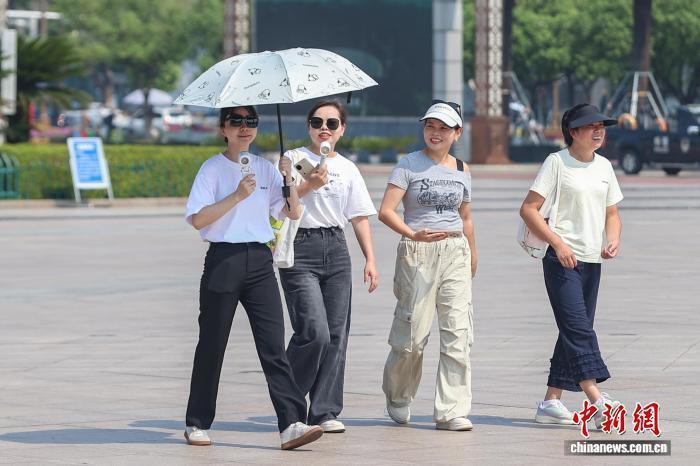 10月11日,江西南昌,市民撑伞、手拿小风扇出行。刘力鑫 摄