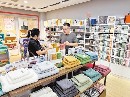 9月15日，河北永亮纺织品有限公司展厅，销售人员（右）向采购商介绍产品。 本报记者 常方圆摄