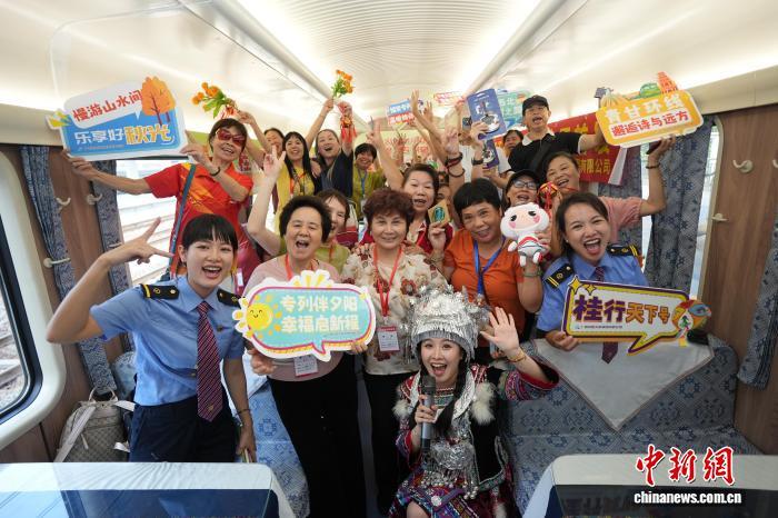 图为旅客与工作人员在“桂行天下号”普惠适老化旅游专列车厢里互动 兰轲艨 摄