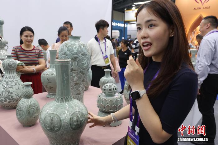 图为参展商工作人员正在向参观者介绍现场展销的朝鲜高丽青瓷。中新社记者 刘占昆 摄