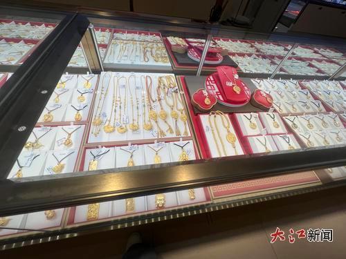 展台陈列多款金饰,“福”字吊坠与宝宝锦鲤锁等热门款亮眼。
