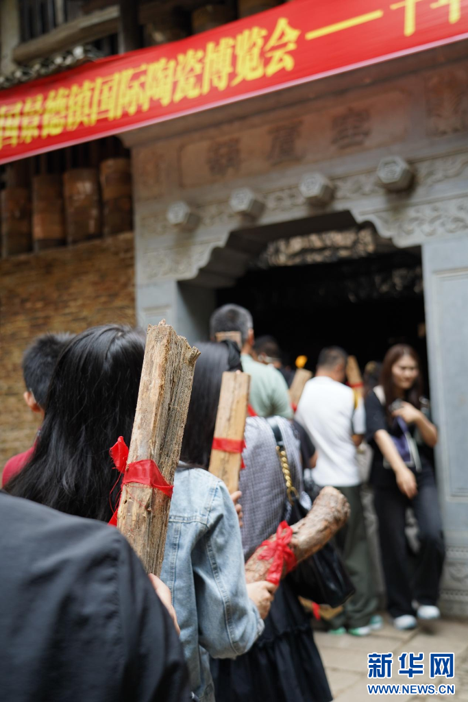 来自全国各地的游客正在参与“人人加柴&middot;家家财旺”烧窑体验活动。新华网发