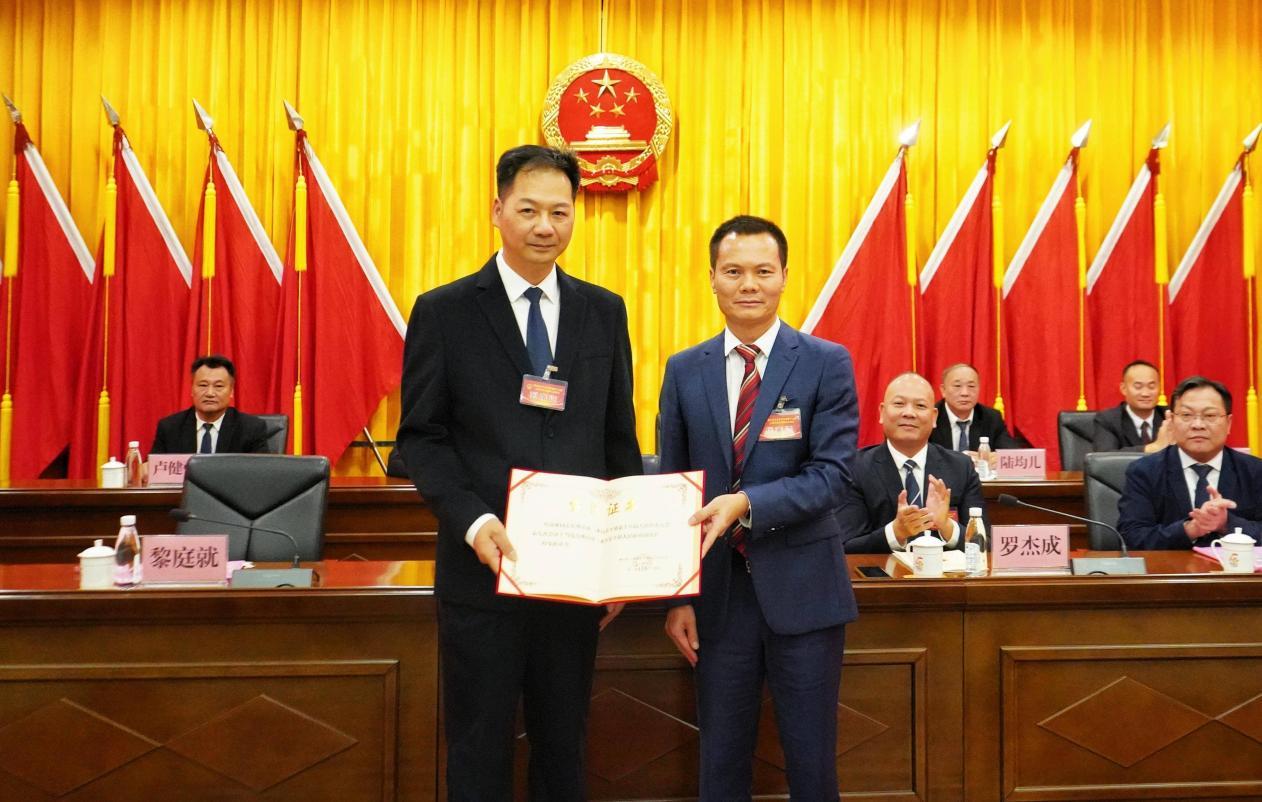 图注:乐平镇人大主席黎庭就(右)为新当选的副镇长叶沛雄(左)颁发当选证书