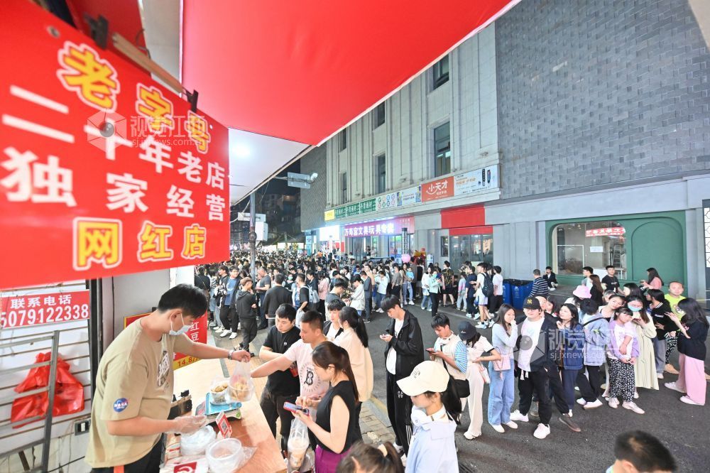 来自全国各地的游客们争相购买南昌的特色小吃(李劼摄)