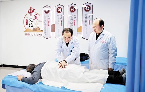 10月21日，沙河市中医院主任医师胡先兴（左）在册井镇中心卫生院国医堂为中医师示范推拿技术。本报记者 赵永辉摄