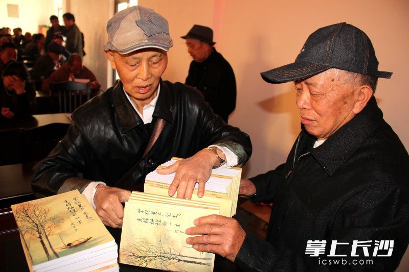 成定海(右二)正在给参加重阳节活动的老党员分发自己著作的《紧跟共产党走 光辉灿烂的一生》一书。均为长沙晚报全媒体记者 贺文兵 摄