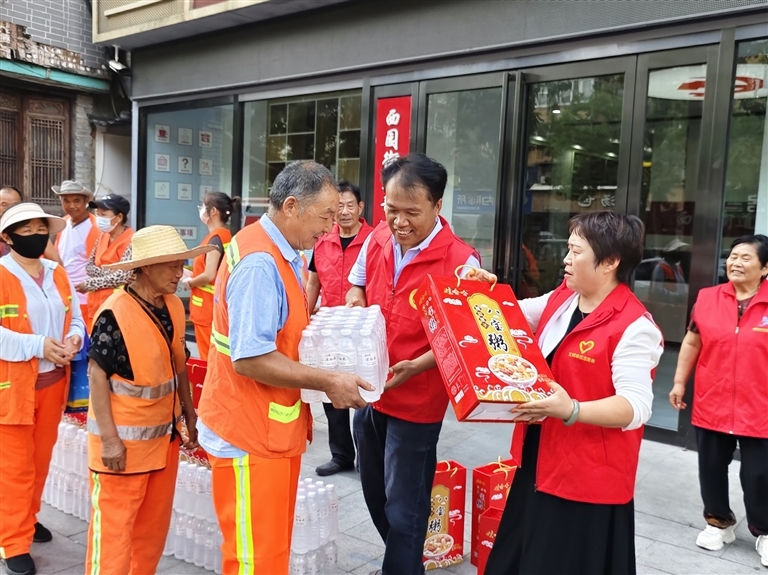 中国好人郭保刚(中)和爱心志愿者慰问环卫工人。