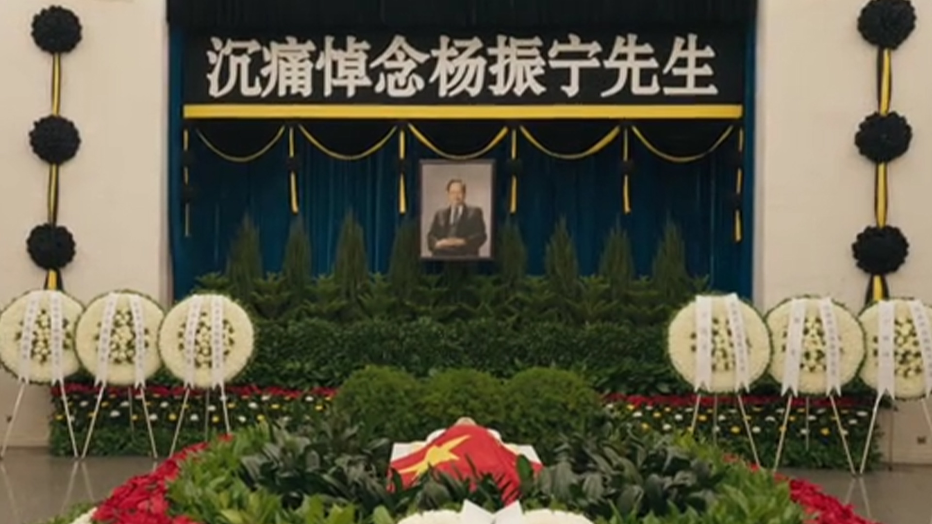 杨振宁遗体告别仪式举行：遗体安卧鲜花翠柏丛中，身上覆盖鲜红国旗
