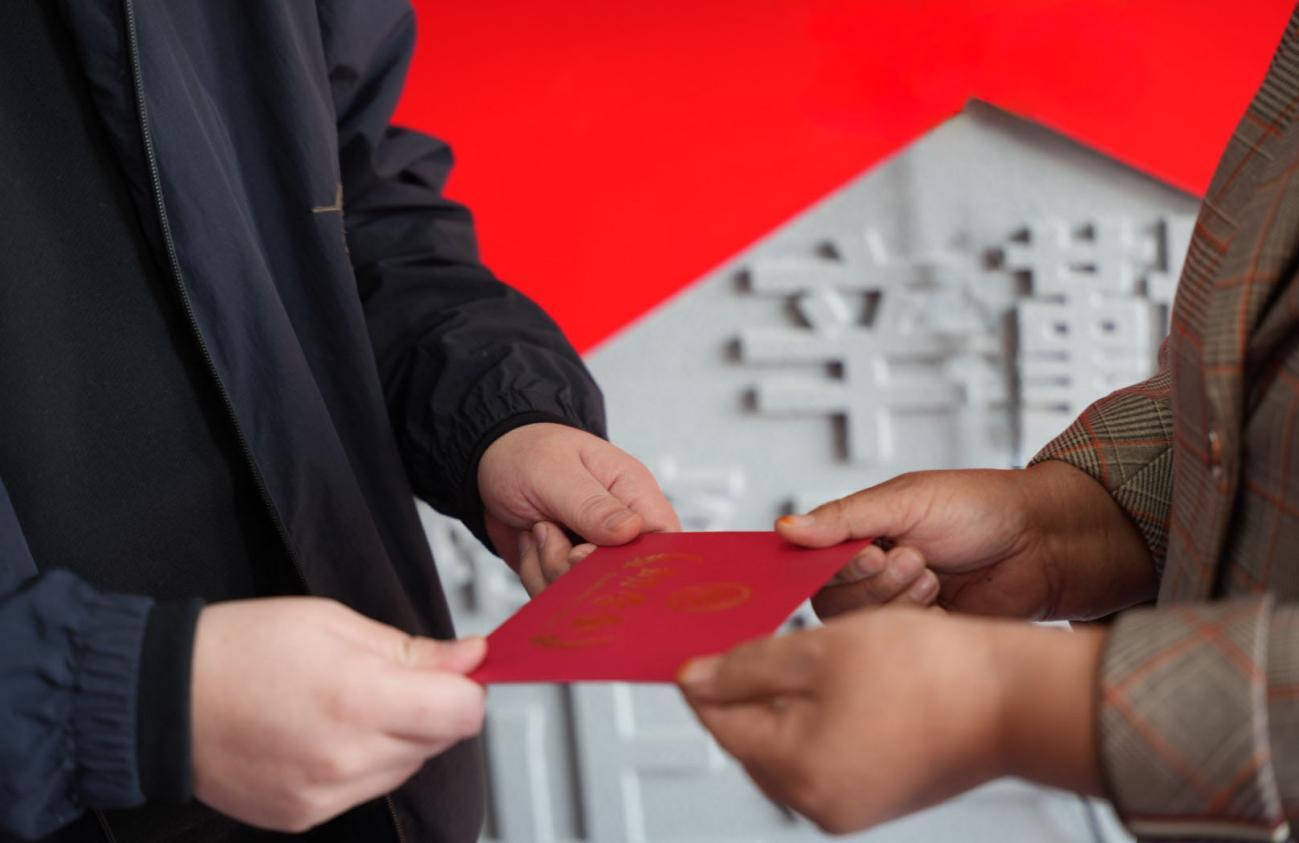 河北鑫泉石油化工有限公司总经理刘渠为学生家长递上助学金。金安娜摄