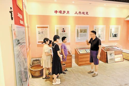 8月9日,阜城县霞口镇刘老人村史馆内,村民刘风义(右一)向孩子们介绍村史。 本报记者 焦磊摄