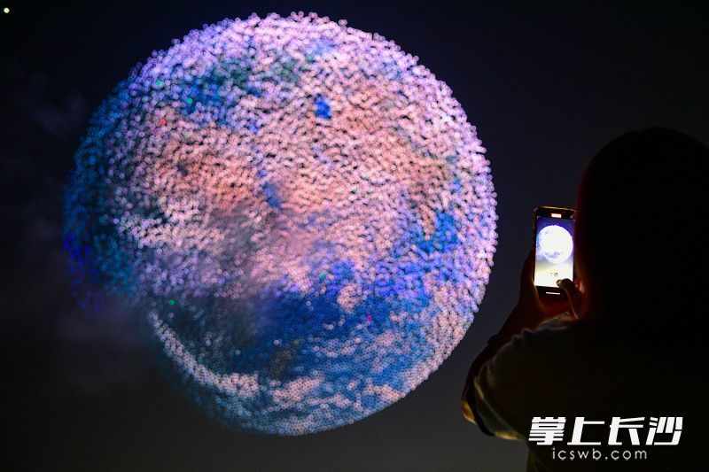 无人机编队勾勒出地球轮廓，蓝色海洋、白色云层与斑斓陆地清晰可见。