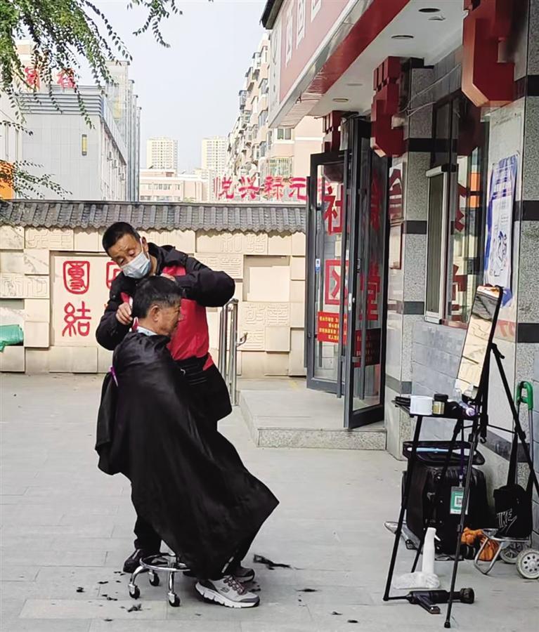 秦师傅在“爱心剪发区”为居民理发