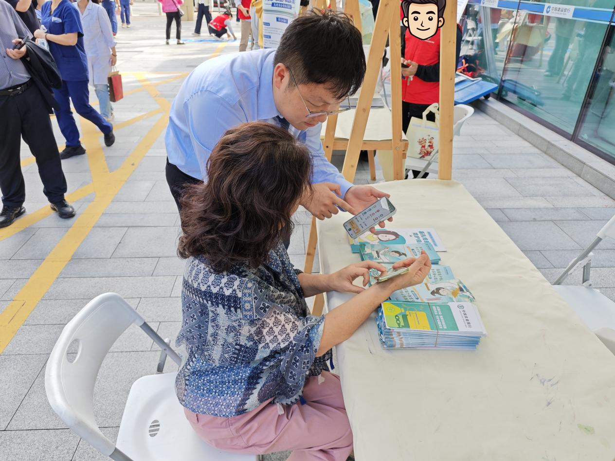 农行深圳中心区支行工作人员向长辈客户介绍农行掌银APP“大字版”功能