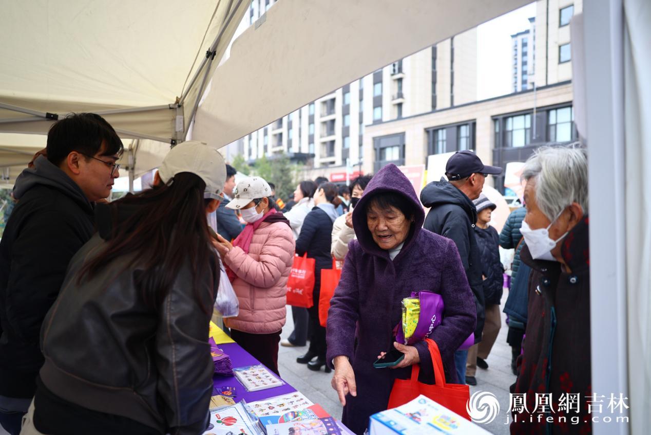 居民在展区前咨询家政服务项目