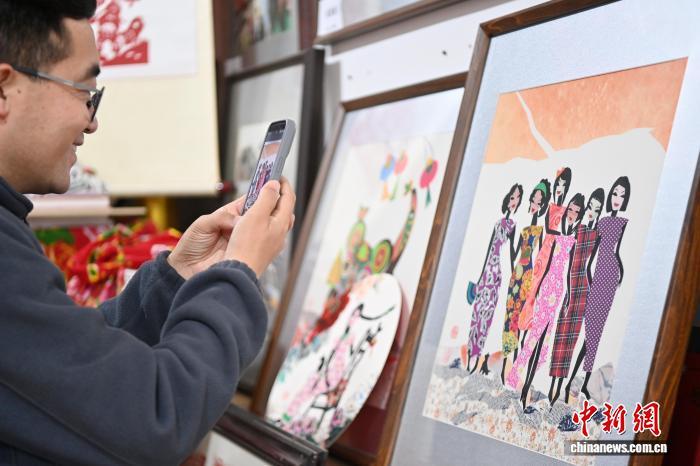 10月24日,在甘肃庆阳市西峰区锦绣坊,民间手艺人张锐利从生活中汲取灵感,用一双巧手将边角碎布变废为宝创作布贴画。布贴画源于陇东地区妇女缝补衣物的智慧,以碎布为料,经剪拼贴缝成画。2024年12月,庆阳民间布贴画艺术被列入甘肃省第五批省级非物质文化遗产代表性项目名录。图为观众参观张锐利创作的布贴画作品。中新社记者 九美旦增 摄