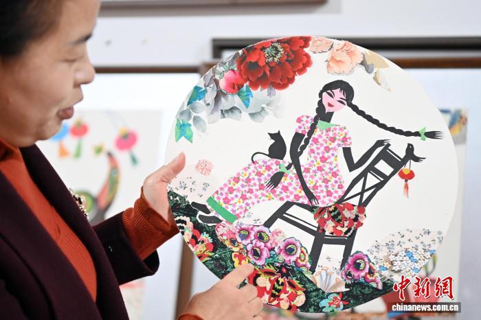 10月24日,在甘肃庆阳市西峰区锦绣坊,民间手艺人张锐利从生活中汲取灵感,用一双巧手将边角碎布变废为宝创作布贴画。布贴画源于陇东地区妇女缝补衣物的智慧,以碎布为料,经剪拼贴缝成画。2024年12月,庆阳民间布贴画艺术被列入甘肃省第五批省级非物质文化遗产代表性项目名录。图为张锐利以现实生活为题材创作出富有当地乡土特色的作品。中新社记者 九美旦增 摄