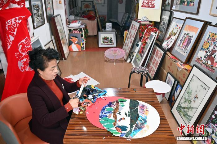 10月24日,在甘肃庆阳市西峰区锦绣坊,民间手艺人张锐利从生活中汲取灵感,用一双巧手将边角碎布变废为宝创作布贴画。布贴画源于陇东地区妇女缝补衣物的智慧,以碎布为料,经剪拼贴缝成画。2024年12月,庆阳民间布贴画艺术被列入甘肃省第五批省级非物质文化遗产代表性项目名录。图为张锐利正在创作布贴画。中新社记者 九美旦增 摄