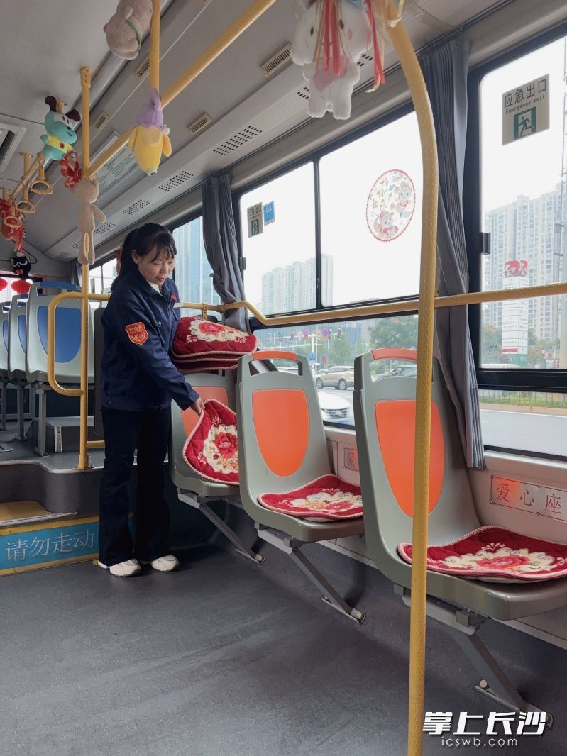 罗爱玉给公交座椅铺坐垫。 长沙晚报全媒体记者 周小华 摄