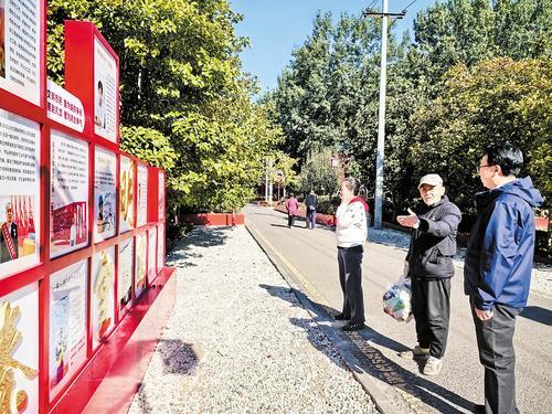 10月21日，在秦皇岛市海港区双争主题公园，市民在认真观看典型人物事迹展板。 本报记者 宋柏松摄