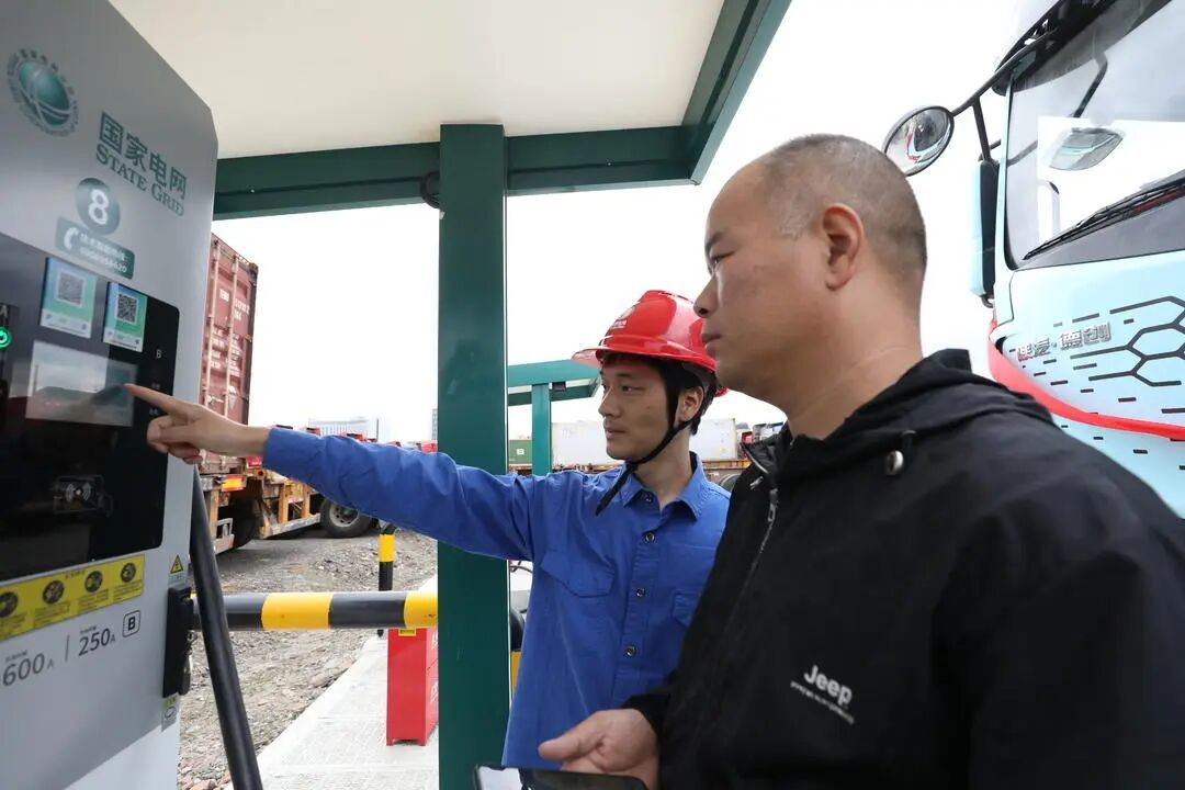 工作人员为集卡司机介绍如何使用充电桩
