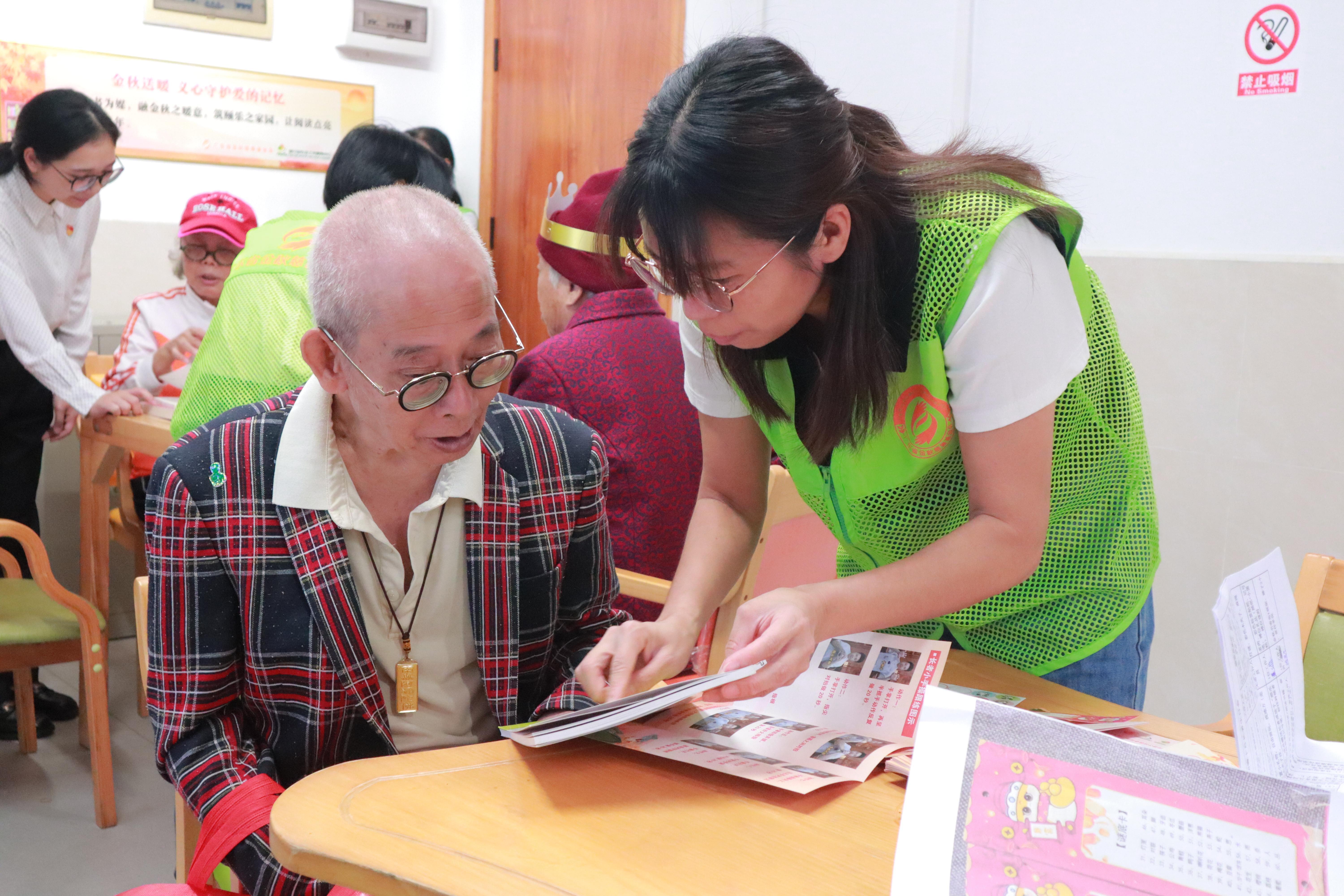 广东省金秋慈善基金会的志愿者陪长者在“金秋·颐乐书香角”阅读图书