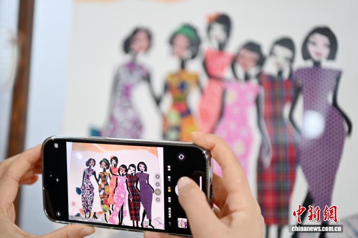 10月24日,在甘肃庆阳市西峰区锦绣坊,民间手艺人张锐利从生活中汲取灵感,用一双巧手将边角碎布变废为宝创作布贴画。布贴画源于陇东地区妇女缝补衣物的智慧,以碎布为料,经剪拼贴缝成画。2024年12月,庆阳民间布贴画艺术被列入甘肃省第五批省级非物质文化遗产代表性项目名录。图为参观者拍摄张锐利创作的布贴画作品。中新社记者 九美旦增 摄