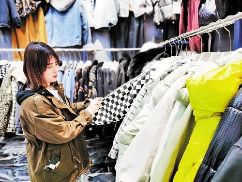 10月23日,在永清县云裳小镇,顾客挑选服装。