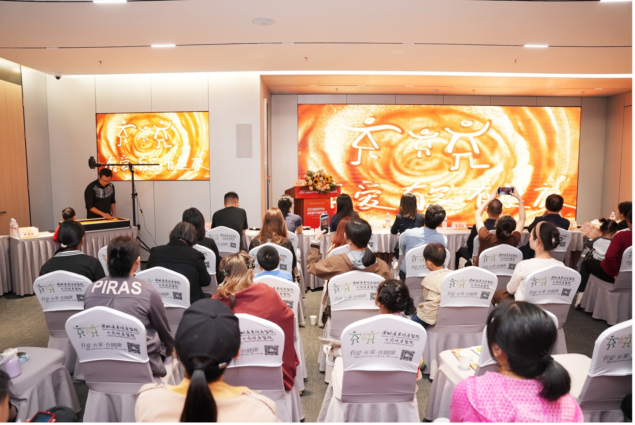 ▲特邀广东省民间文艺家协会沙画专委会副主任、逆时针沙画艺术家肖思鑫老师现场演绎《金秋圆梦路》