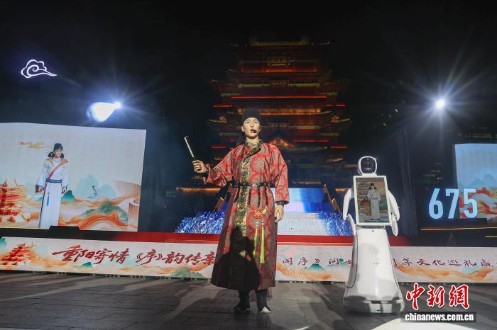 图为演员扮演的王勃（图中）与王勃数字分身（图左屏幕）、王勃AI智能机器人（图右）在滕王阁前共同登场。中新社记者 刘力鑫 摄