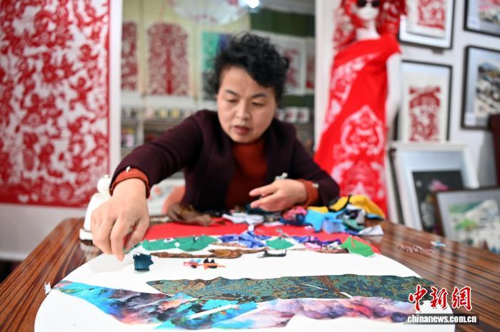 10月24日,在甘肃庆阳市西峰区锦绣坊,民间手艺人张锐利从生活中汲取灵感,用一双巧手将边角碎布变废为宝创作布贴画。布贴画源于陇东地区妇女缝补衣物的智慧,以碎布为料,经剪拼贴缝成画。2024年12月,庆阳民间布贴画艺术被列入甘肃省第五批省级非物质文化遗产代表性项目名录。图为张锐利正在创作布贴画。中新社记者 九美旦增 摄