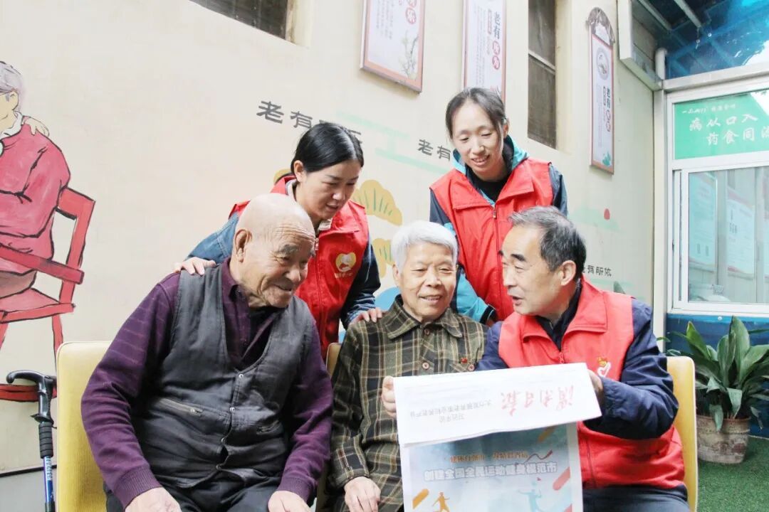 小板凳志愿者为老人读报纸