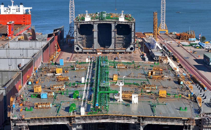 ▎在山东烟台黄渤海新区一家造船企业,多座大型船舶船体分段在建造中。(图源:东方ic)