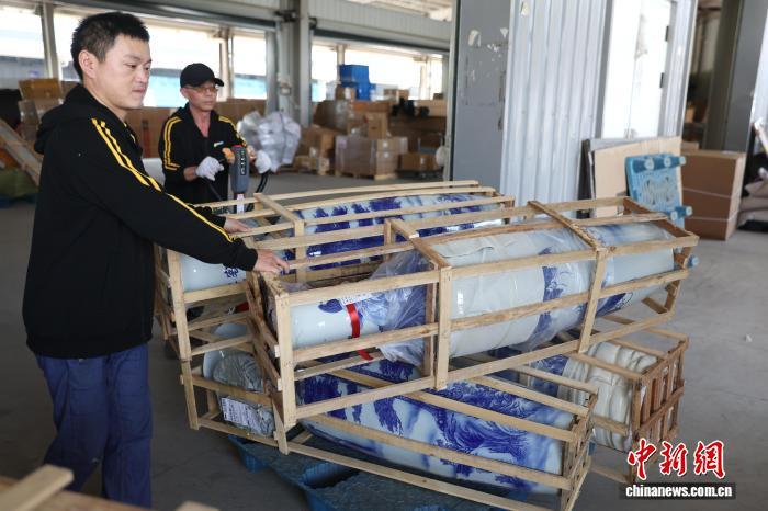 图为一家物流企业工作人员使用拖车搬运大型瓷瓶。中新社记者 刘占昆 摄