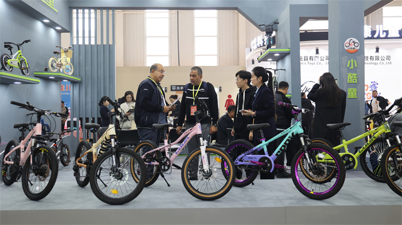 11月6日,在第二十届中国·北方(平乡)国际自行车童车玩具博览会上,参展企业工作人员向外国客商介绍产品。