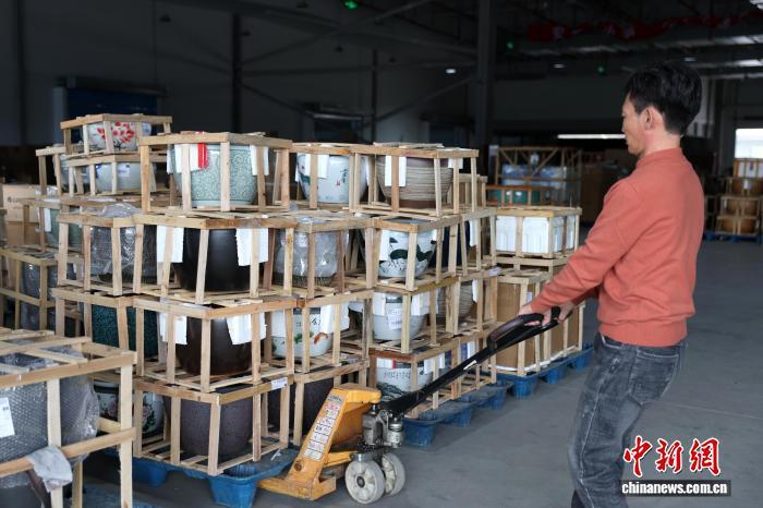 图为现场一家物流企业工作人员正在搬运陶瓷水缸。中新社记者 刘占昆 摄