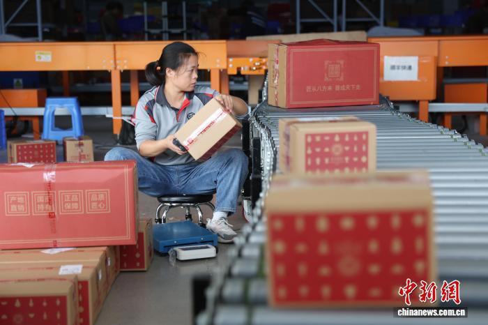 图为一家物流企业工作人员正在有序分拣自动传送带上的陶瓷货物。中新社记者 刘占昆 摄