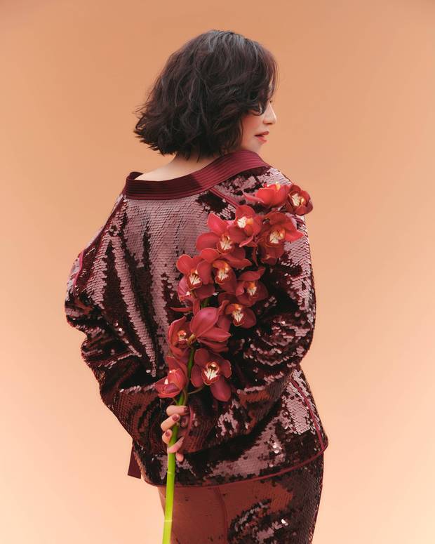 惠英红手持红花,背影窈窕。