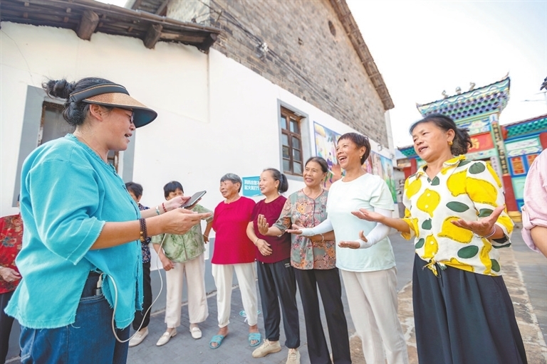 谢爱莲（左一）指导“庙口妈妈”们练习准备拍摄的短视频台词。