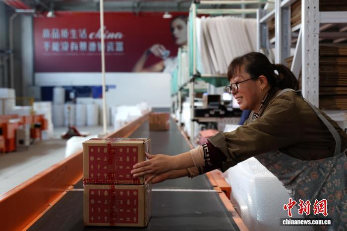 图为一家物流企业工作人员把打包好的陶瓷商品放到自动传送带上。中新社记者 刘占昆 摄