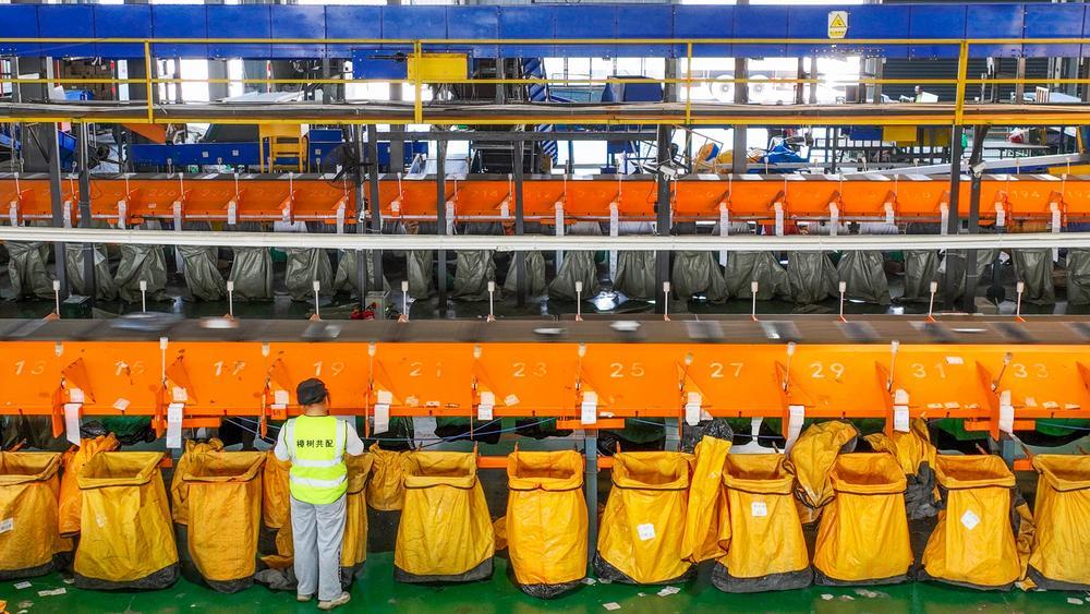 樟树市邮政共配中心工作人员正在进行邮政快递分拣作业