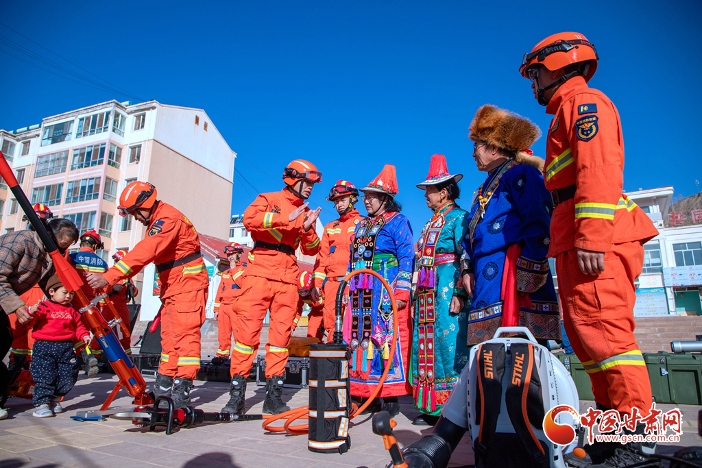 消防队员给裕固族群众讲解地震救援装备液压扩张器在救援中的用途