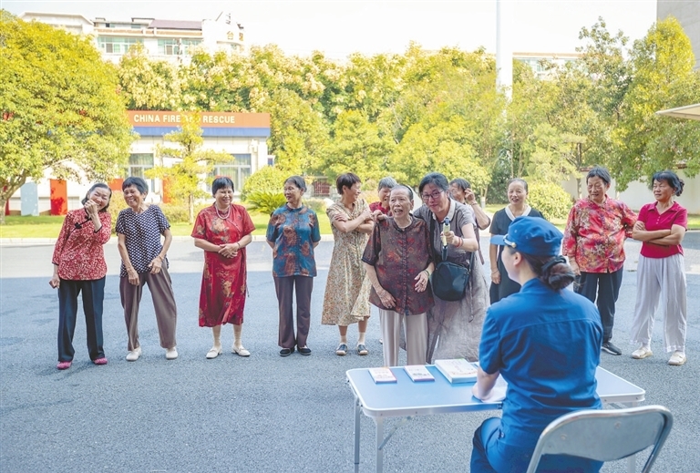 “庙口妈妈”们和消防员一起拍摄趣味问答视频，现场笑声不断。