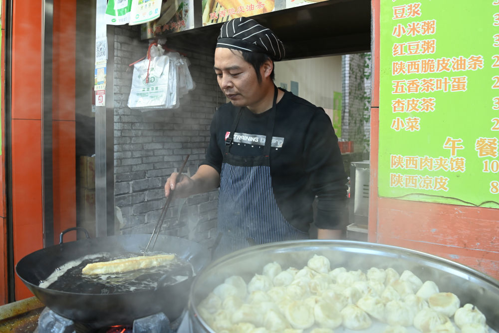 李勇正在为顾客炸油条　新华社记者　范培珅　摄