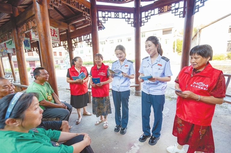 “庙口妈妈”们与税务部门工作人员一起，向村民普及税法和社保办理知识。