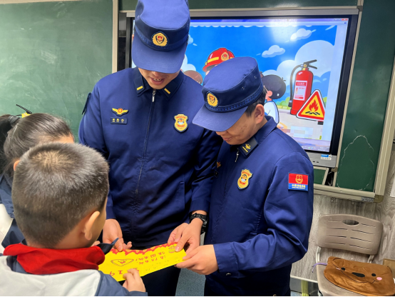 11月3日，在石家庄市草场街小学四年级三班教室，同学们将画的手抄报送给消防员。李雨桐摄