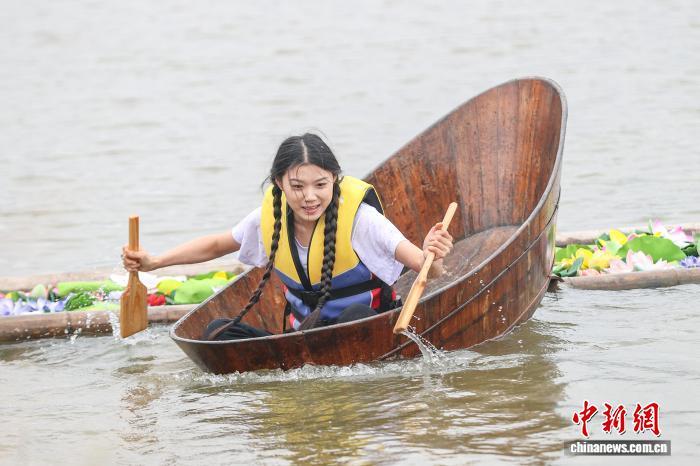 图为荷塘采莲项目中,选手划着木盆去采莲花道具。中新社记者 刘力鑫 摄