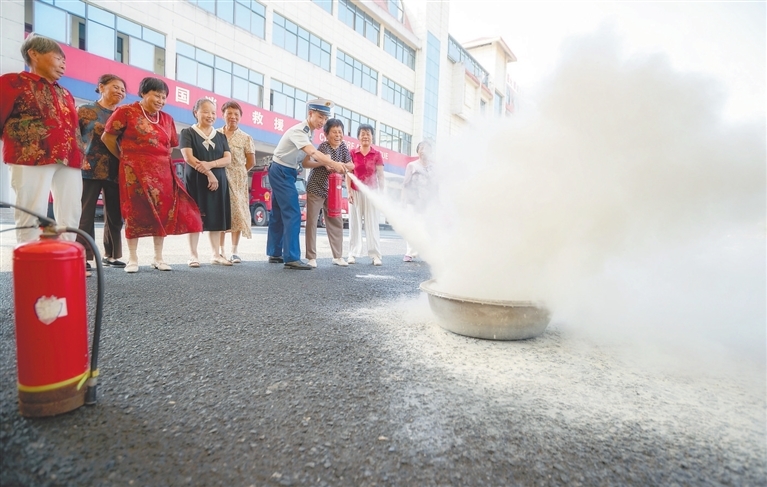 “庙口妈妈”们在峡江县消防救援大队消防员的指导下使用灭火器。