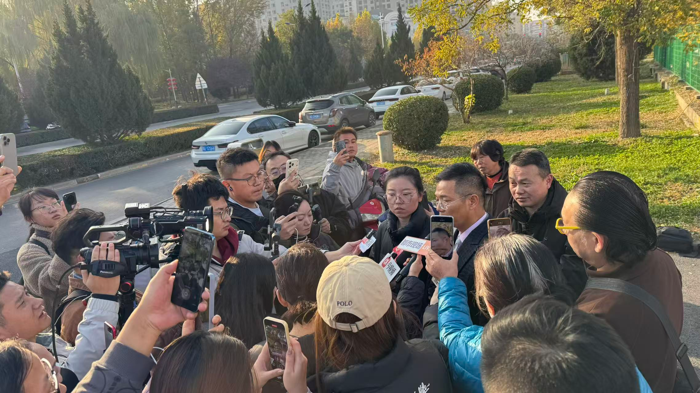 11月13日上午开庭前,被告人女儿和被告人辩护律师在法院门口接受媒体采访。