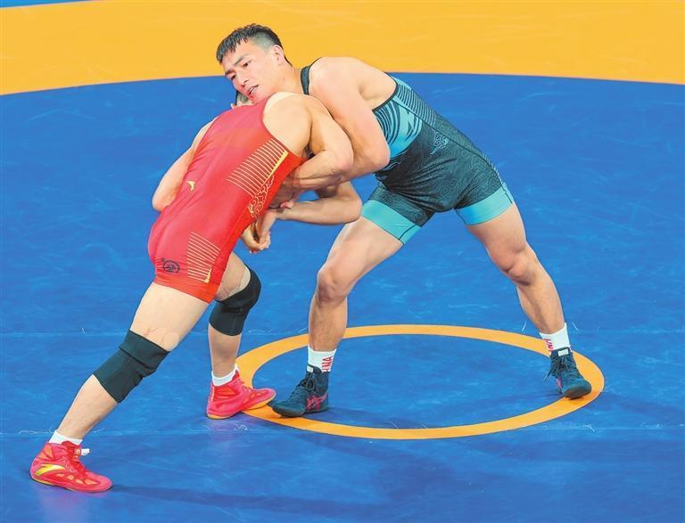 11月12日,甘肃省运动员呼斯乐吐(右)在男子古典式摔跤67公斤级决赛中。